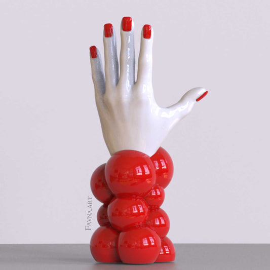 Scultura contemporanea figurativa di design per interni moderni: mano femminile con unghie smaltate e sfere astratte. Scultura artistica moderna in rosso.