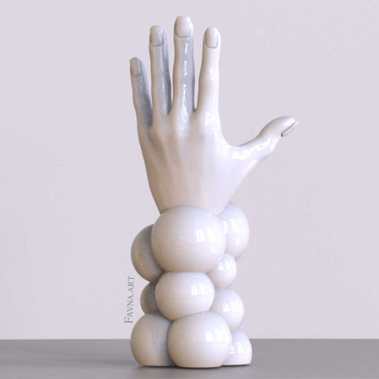 Scultura contemporanea figurativa di design per interni moderni: mano femminile con unghie smaltate e sfere astratte. Scultura artistica moderna in bianco.