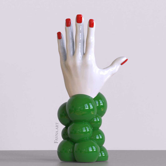Scultura contemporanea figurativa di design per interni moderni: mano femminile con unghie smaltate e sfere astratte. Scultura artistica moderna in rosso bianco e verde.