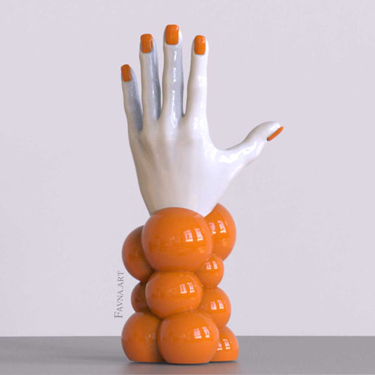 Scultura contemporanea figurativa di design per interni moderni: mano femminile con unghie smaltate e sfere astratte. Scultura artistica moderna in arancione.